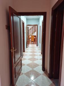 a hallway with an open door and a tiled floor at Piso Levante in Arcos de la Frontera