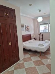 a bedroom with a bed and a wooden door at Piso Levante in Arcos de la Frontera