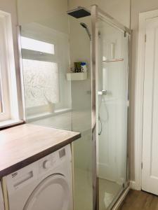 a bathroom with a shower and a washing machine at Quiet residence close to M6 Preston in Samlesbury