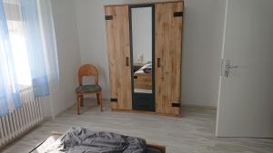 a bedroom with a mirror and a chair and a bed at Apartment Ferienwohnung Vogt in Sinzheim