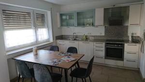 a kitchen with a wooden table and chairs at Apartment Ferienwohnung Vogt in Sinzheim