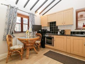 a kitchen with a table and chairs in a room at Brook Cottage in Abergavenny