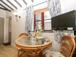 a dining room with a glass table and chairs at Brook Cottage in Abergavenny