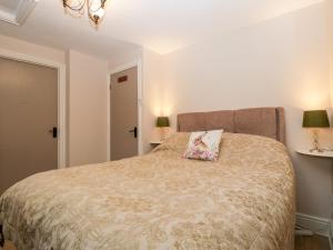a bedroom with a bed with a pillow on it at Brook Cottage in Abergavenny