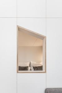a mirror in a white room with a bed at Stylish New Cube Loft II by Berlin-Wall-Apartments in Berlin