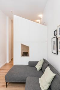 a couch in a room with a white wall at Stylish New Cube Loft II by Berlin-Wall-Apartments in Berlin