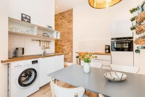 a kitchen with a table and a washing machine at Stylish New Cube Loft II by Berlin-Wall-Apartments in Berlin