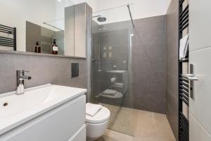 a bathroom with a sink and a toilet and a shower at Stylish New Cube Loft II by Berlin-Wall-Apartments in Berlin