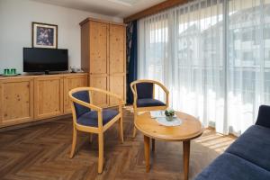 a living room with a table and two chairs and a tv at Hotel Garni Alpenruh-Micheluzzi in Serfaus