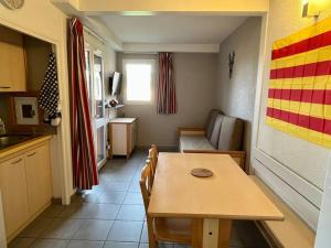 une cuisine avec une table et une salle à manger dans l'établissement Charmant appartement en résidence de vacances avec piscine, à Argelès-sur-Mer