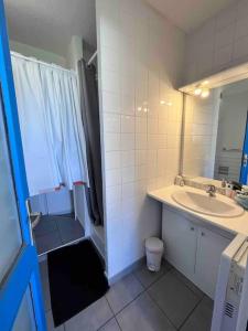 La salle de bains blanche est pourvue d'un lavabo et d'une douche. dans l'établissement Charmant appartement en résidence de vacances avec piscine, à Argelès-sur-Mer
