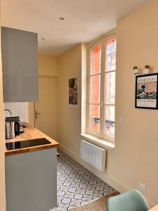 a kitchen with a counter top and a window at Le Petit Flaubert in Trouville-sur-Mer