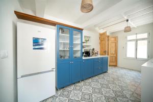 uma cozinha com armários azuis e um frigorífico branco em MINIQ HOMES 104 - The Luxurious Stone Retreat em Foça