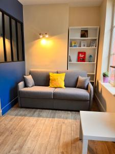 sala de estar con sofá y almohadas amarillas en Le Petit Flaubert en Trouville-sur-Mer
