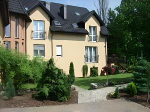 a yellow house with a black roof at Hotel Zieliniec in Poznań