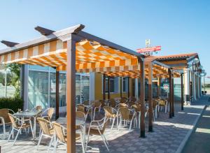 un restaurante con mesas y sillas bajo toldo en Hotel Camino Real, en Dueñas