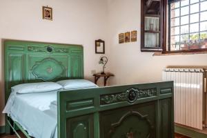 a bedroom with a green bed and a window at La Moiana in San Quirico dʼOrcia