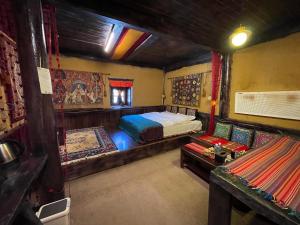 een slaapkamer met een bed en een bank erin bij Timeless Inn in Shangri-La