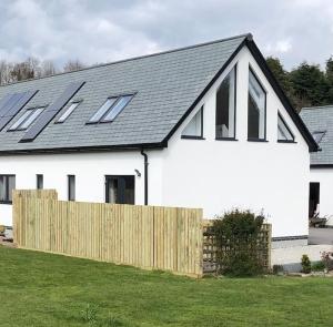 una casa bianca con pannelli solari sul tetto di Home from Home self catering for 2 a St Austell