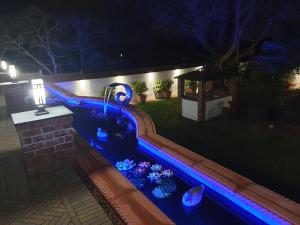 a swimming pool with blue lights in a yard at night at Best Area Close to Leeds Centre in Leeds