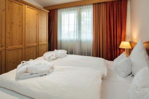 a bedroom with two beds with white towels on them at Hotel Garni Alpenruh-Micheluzzi in Serfaus
