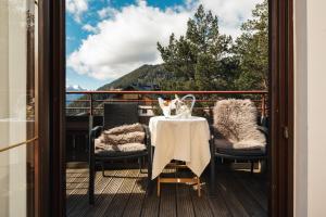 a table and chairs on a balcony with a view at Hotel Garni Alpenruh-Micheluzzi in Serfaus