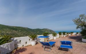 twee blauwe stoelen en een tafel op een terras met uitzicht op de oceaan bij Casa Mattinatella in Mattinata