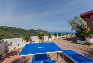 een blauwe picknicktafel met twee stoelen en de oceaan bij Casa Mattinatella in Mattinata