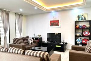 a living room with two couches and a flat screen tv at Desaru Utama Villa by Antlerzone in Bandar Penawar