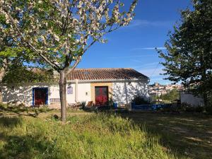 una casa blanca con una puerta roja y un árbol en Ola Linda - Casa de Campo -, en Castelo de Vide