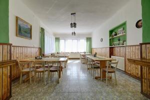 a dining room with wooden tables and chairs at Elimheim in Cisnădioara