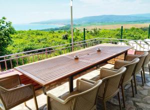 a wooden table and chairs on a balcony with a view at Villa Meraki in Byala