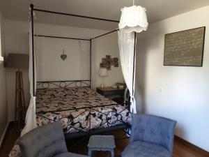 Douvres-la-Délivrande的住宿－LA MAISON DE NACRE，一间卧室配有一张床和两张蓝色椅子