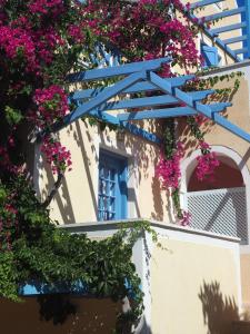 a building with flowers on the side of it at Asterias Mini Coastal Apartments in Perivolos