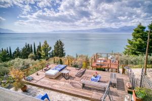 a wooden deck with a view of the water at Magical view, Villa Asproneri, Kamena Vourla in Kamena Vourla