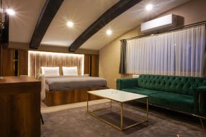Habitación de hotel con cama y sofá verde en Anatolia Luxury Hotel en Bakanlıklar