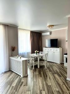 sala de estar con mesa y cocina en Golden Era Apart en Kryzhanivka