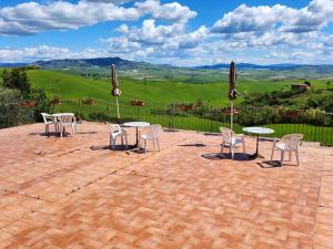 a patio with tables and chairs with a view at AGRITURISMO LUCESTRAIA in Montecatini Val di Cecina