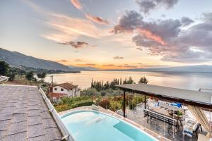 a house with a swimming pool and a view of the water at Magical view, Villa Asproneri, Kamena Vourla in Kamena Vourla