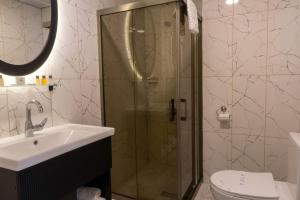 a bathroom with a shower and a toilet and a sink at Anatolia Luxury Hotel in Bakanlıklar