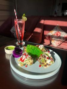 un plato de comida en una mesa con una bebida en HOTEL JS SOUVENIR en Dehradun