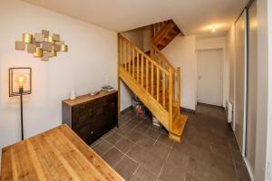 a hallway with a wooden staircase in a house at MAISON TOUT CONFORT - NATURE - CALME - 98m2 in Le Verdier