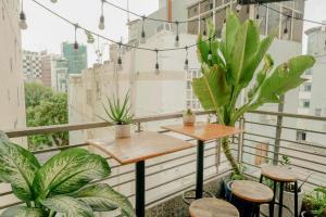 a balcony with plants and a table and stools at Galaxy Boutique Sai Gon Hotel - by Bay Luxury in Ho Chi Minh City