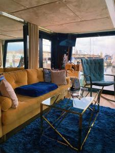 ein Wohnzimmer mit einem Sofa, einem Tisch und Stühlen in der Unterkunft Hausboot mit Traumlage in Travemünde in Rönnau