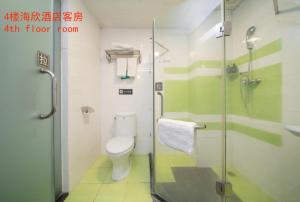 a bathroom with a toilet and a glass shower at Chaoman Hotel -Guangzhou Shijing City Plaza Xiaoping Subway Station in Guangzhou