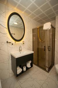 a bathroom with a sink and a shower and a mirror at Anatolia Luxury Hotel in Bakanlıklar
