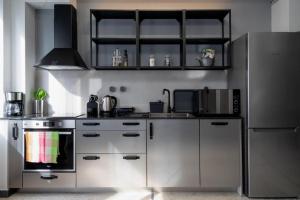 een keuken met roestvrijstalen apparatuur en een koelkast bij Epikourou Loft 20 in Athene