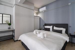 een slaapkamer met een groot wit bed en handdoeken bij Epikourou Loft 20 in Athene