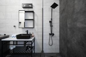 een badkamer met een wastafel en een douche bij Epikourou Loft 20 in Athene