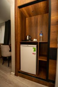 een kleine koelkast in een keuken met een plank bij Anatolia Luxury Hotel in Bakanlıklar
